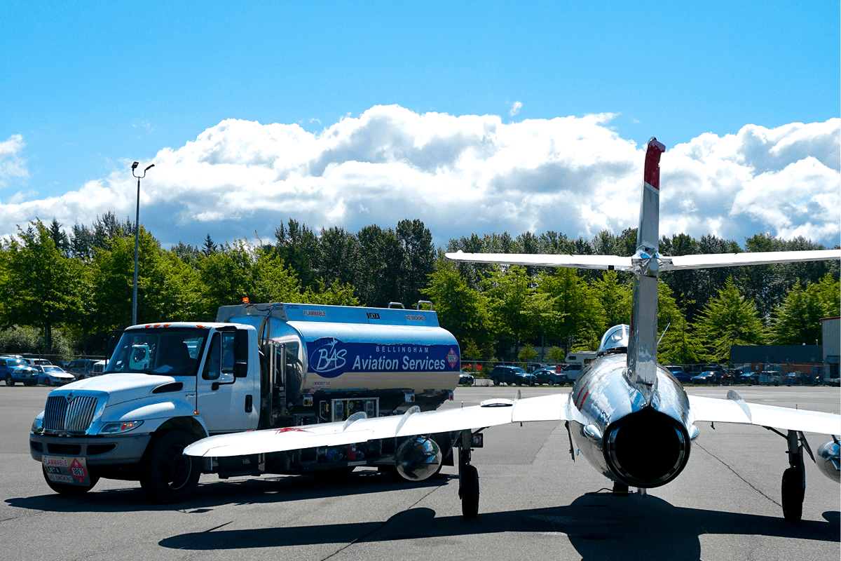 Fuel truck refueling a parked airplane.