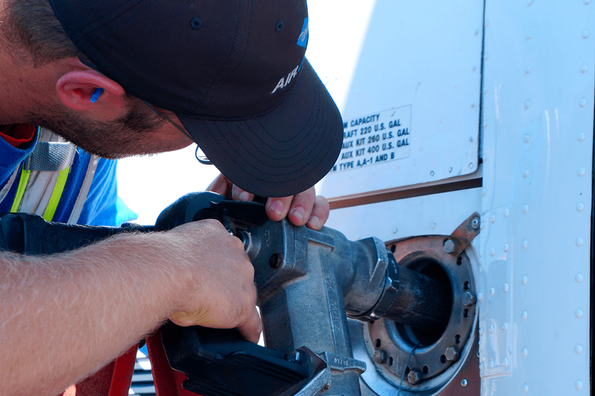 Worker fueling an aircraft with equipment.