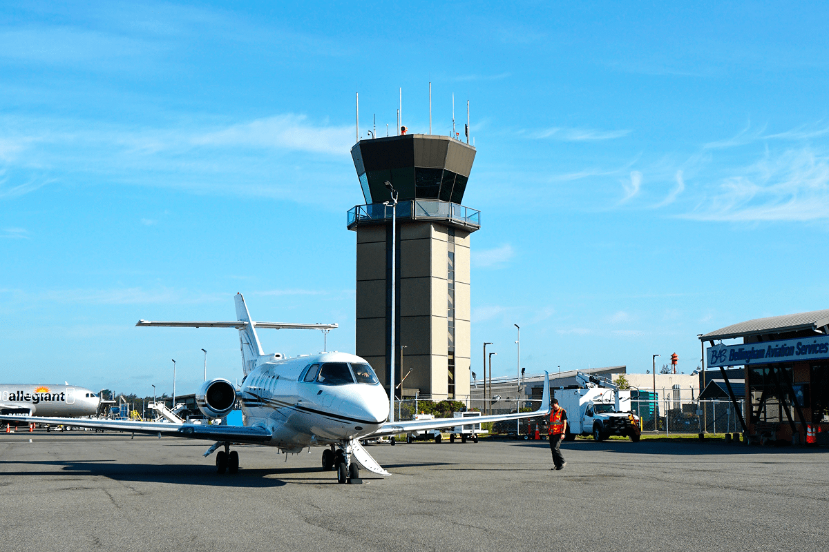 Private jet at airport near control tower.