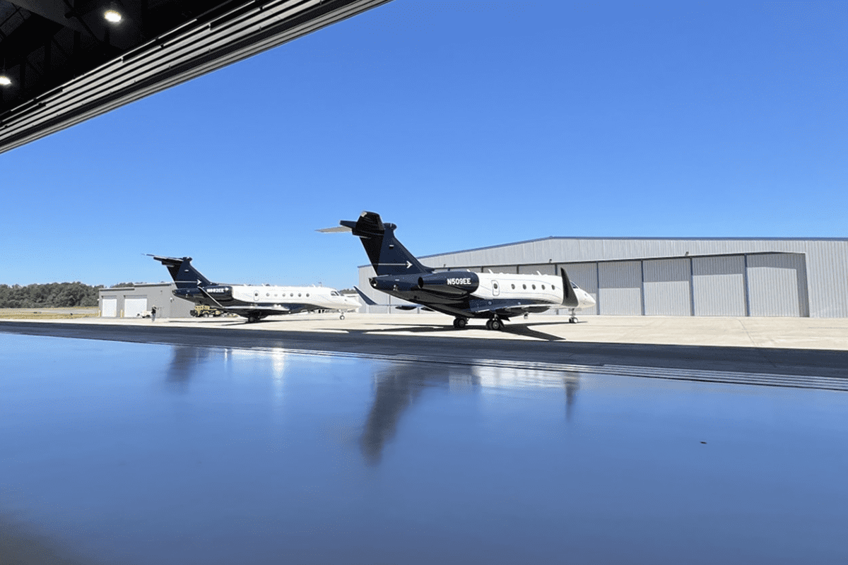 Two private jets parked at airport hangar.