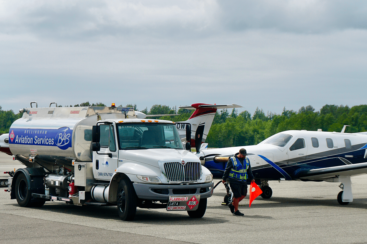 Fuel truck and small airplane at airport.