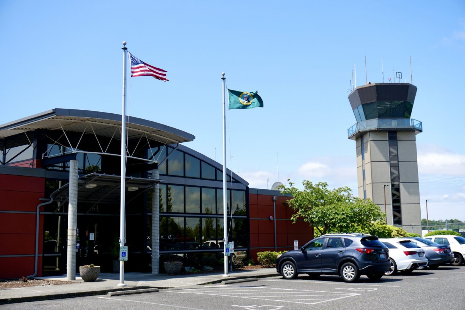 Airport terminal with control tower and flags.
