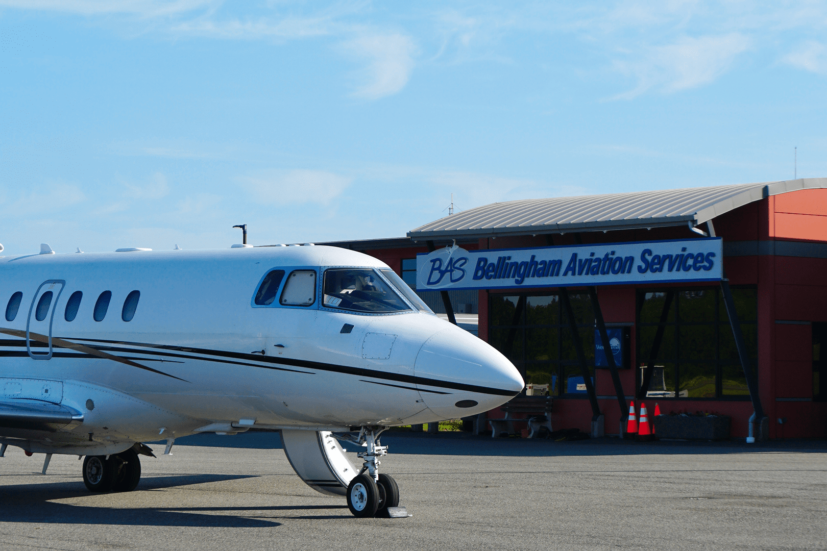 Private jet near aviation services building.