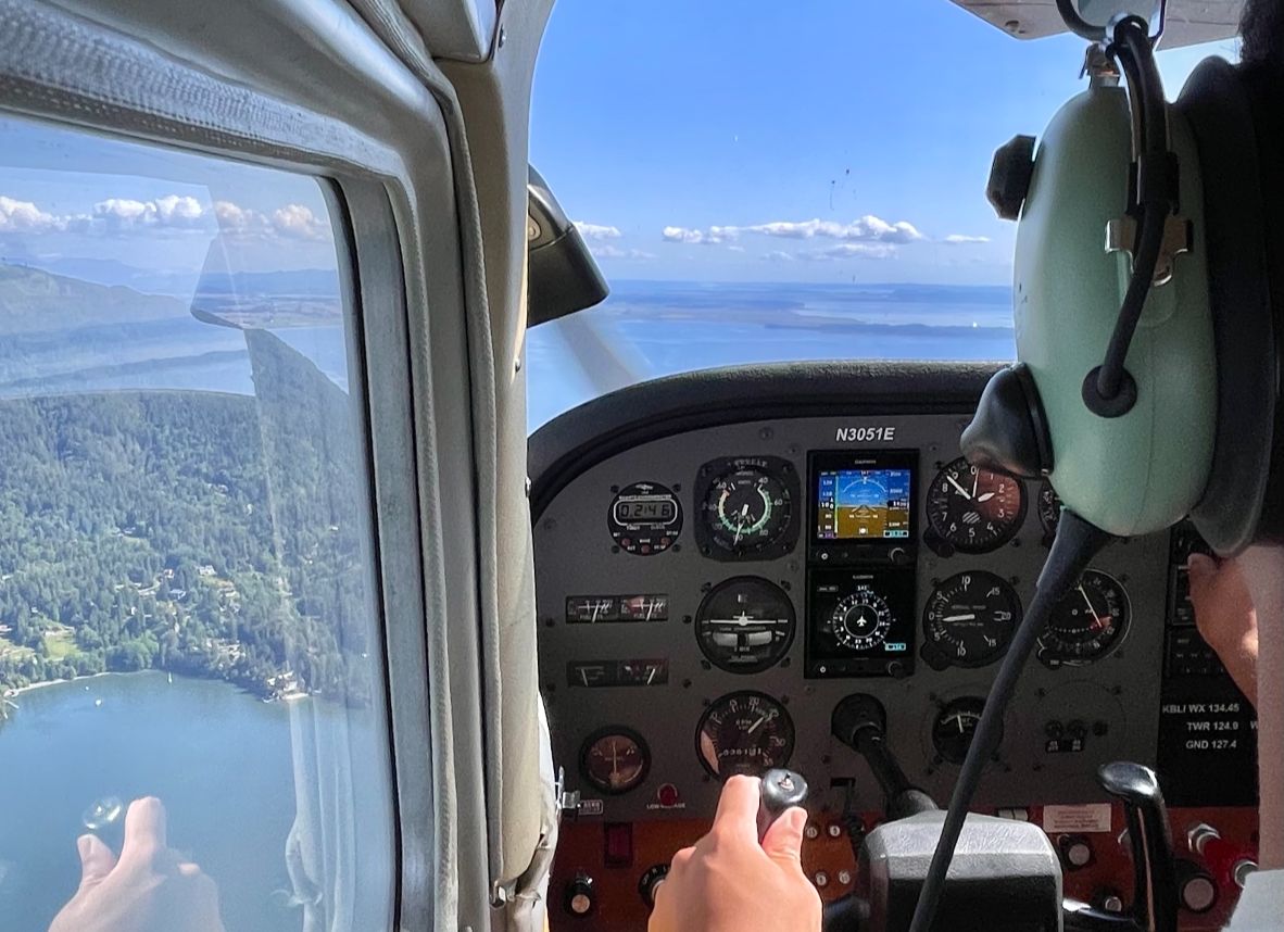Cockpit view over coastal lake with pilot