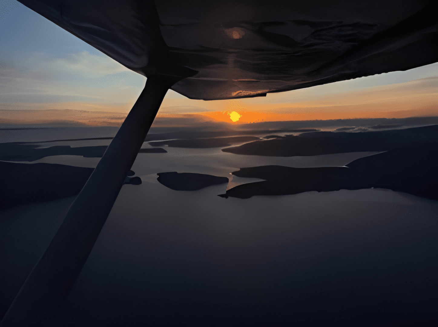 Sunset view from airplane over islands.
