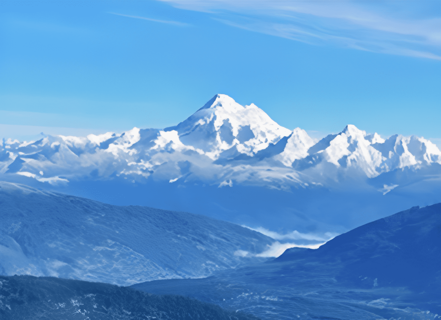 Snow-covered mountain peaks under clear sky.