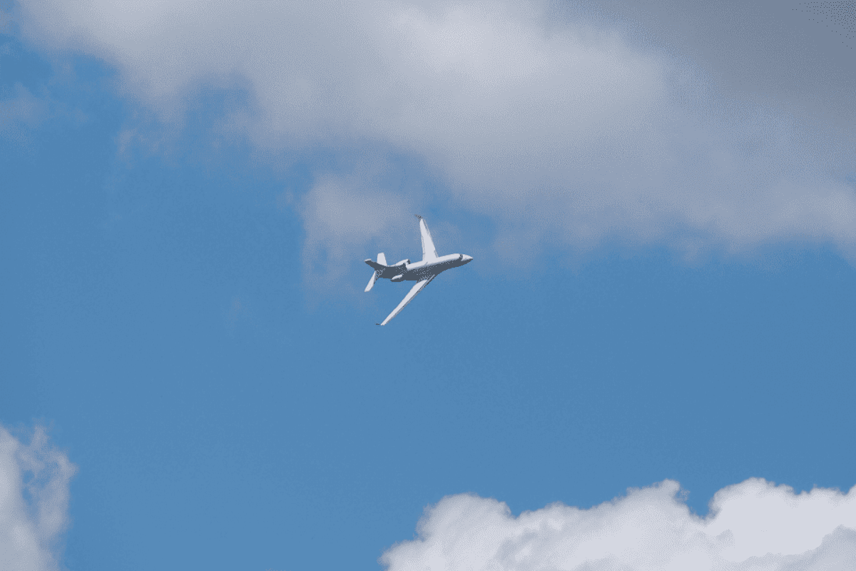 White airplane against blue cloudy sky