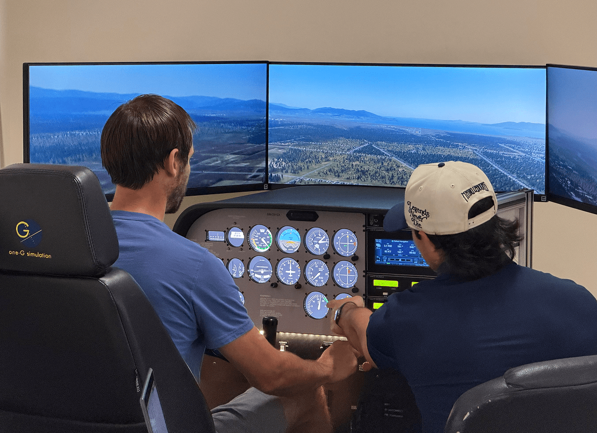 Two people using a flight simulator.