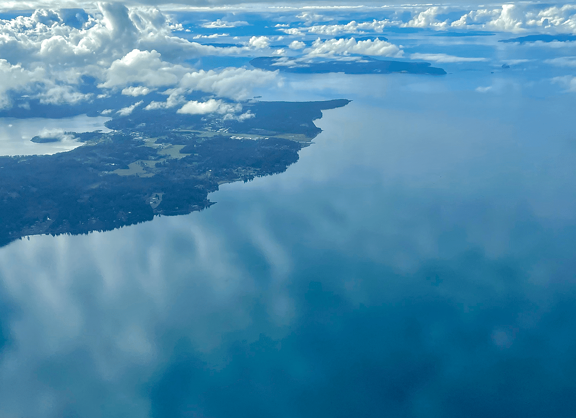 Aerial view of coastline and clouds.
