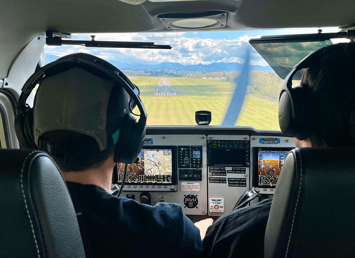 Pilots landing small plane, cockpit view.